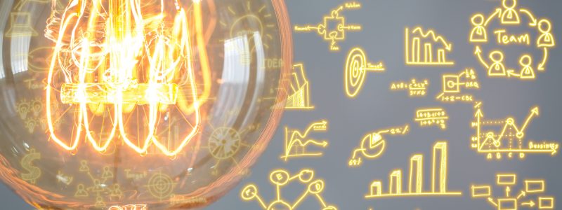 Close up of vintage glowing light bulb with business graph